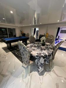 uma sala de jantar com uma mesa com cadeiras e uma mesa de bilhar em Chambre de luxe familiale 95 Bleu em Deuil-la-Barre