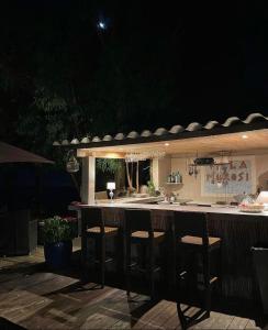 - un bar extérieur avec tabourets dans la cuisine la nuit dans l'établissement Residence VILLA MOROSI - Favone, à Conca