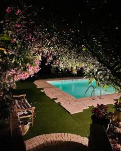 - une piscine dans une cour avec un banc et des fleurs dans l'établissement Residence VILLA MOROSI - Favone, à Conca