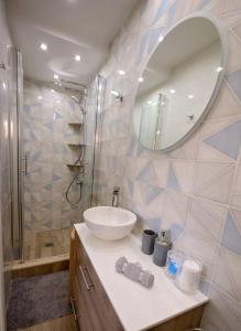 y baño con lavabo y ducha con espejo. en Lia's apartment en Kalymnos