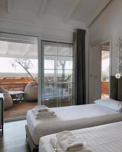 1 dormitorio con 2 camas y balcón en ALEVRA, en Dhërmi