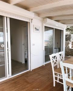 a porch with sliding glass doors and a table and chairs at ALEVRA in Dhërmi