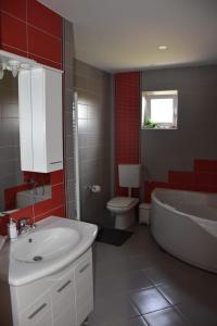 a bathroom with a tub and a toilet and a sink at Kuća za odmor „Slavonska Lola“ in Nuštar