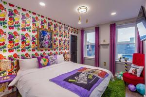 a bedroom with a bed and a colorful wall at King Bed / Free Parking / Arcade / BBQ / Patio in Pittsburgh