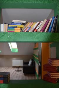 a stack of books sitting on a shelf in a room at Kuća za odmor „Slavonska Lola“ in Nuštar
