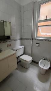 Baño blanco con aseo y lavamanos en Tourist Apartment San Telmo en Buenos Aires