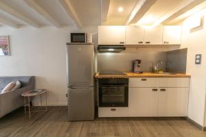 una cucina con armadietti bianchi e frigorifero di CONFORTABLE 2 PIÈCES AU CŒUR DU CENTRE HISTORIQUE a Vienne