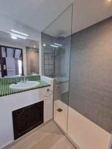 a bathroom with a glass shower and a sink at Canaan Boutique Hotel Ronda in Ronda