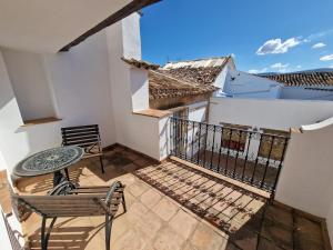 - Balcón con mesa y sillas en un edificio en Canaan Boutique Hotel Ronda, en Ronda