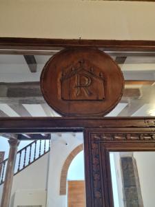 un miroir en bois avec la lettre r au-dessus dans l'établissement Canaan Boutique Hotel Ronda, à Ronda