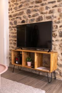 un televisore su un supporto in legno in soggiorno di CONFORTABLE 2 PIÈCES AU CŒUR DU CENTRE HISTORIQUE a Vienne
