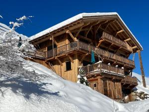 una cabaña de madera en la nieve con nieve en Appartement haut standing Arêches beaufort, en Arêches