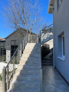 a staircase leading up to a building with a tree at Cezar Apartments in Podgorica