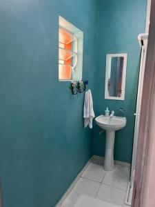 a blue bathroom with a sink and a mirror at Chalé Canto da Viola in São Roque