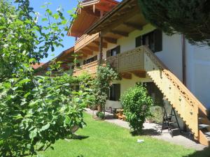 a house with a staircase in the yard at Landhaus Familie Doll Ferienwohnung Sunnawind in Bichl