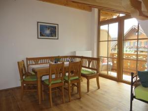 a dining room with a wooden table and chairs at Landhaus Familie Doll Ferienwohnung Sunnawind in Bichl