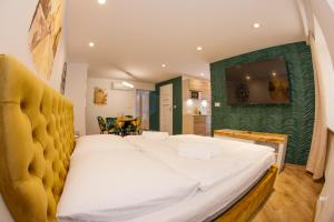 een groot bed in een kamer met een groene muur bij Apartament Książęcy Gold klimatyzacja in Bolesławiec