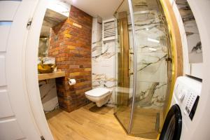 een badkamer met een toilet en een glazen douche bij Apartament Książęcy Gold klimatyzacja in Bolesławiec