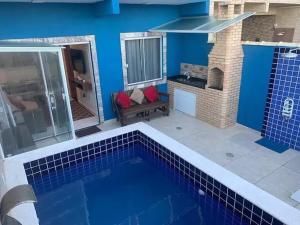 ein blaues Haus mit einem Pool und einem Kamin in der Unterkunft MARCOLINI - Unamar, Conforto em frente a Praia! in Cabo Frio