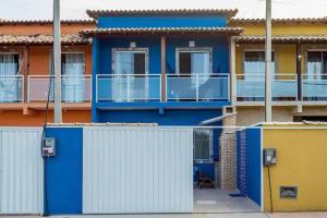un edificio azul y amarillo con balcón en MARCOLINI - Unamar, Conforto em frente a Praia!, en Cabo Frío