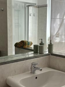 ein Bad mit einem Waschbecken und einem Spiegel in der Unterkunft Casa Gelsomino -Villa with garden, near the Lake in Mandello del Lario