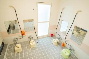 a bathroom with two sinks and two mirrors at 駅前山小屋A-yard in Ome