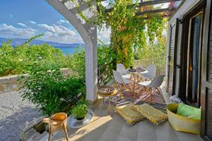 un patio con tavolo, sedie e vista sull'oceano di Villas Vista Del Mar a Kíssamos