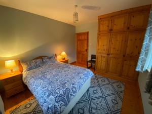 1 dormitorio con 1 cama azul y armarios de madera en Dromkeal View apartment, en Cork