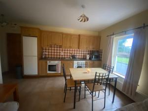a kitchen with a table and chairs and a window at Dromkeal View Apartment in Cork +7 photos