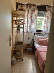 a bedroom with a bed and a ladder next to a window at Melody Birds in Dhíkella