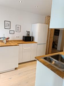 a kitchen with a sink and a white refrigerator at Große Auszeit Eifel mit Sauna, Kamin und Terrasse in Nettersheim