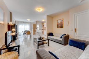a living room with a couch and a tv at 100m to a beach Spacious apartm in Playa de San Juan