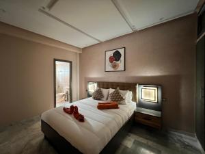 Antonios luxury apartments في فاس: غرفة نوم عليها سرير وحذيين حمر