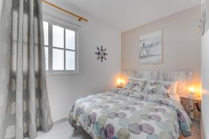 a white bedroom with a bed and a window at 100m to a beach Spacious apartm in Playa de San Juan