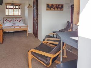 a room with a bed and a table and chairs at The Snug - Uk42088 in Sedbergh