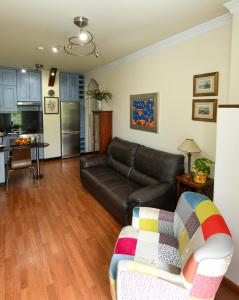 a living room with a leather couch and a kitchen at CASA VIVA in Santa Cruz de la Palma