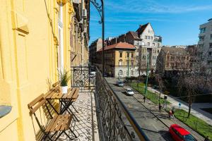 a balcony of a building with two benches and a street at Terrace VuVu - Apartment with balcony in the heart of Budapest in Budapest