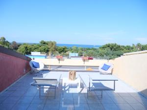 un patio con mesas y sillas en la azotea en Grand Hostel Calabria, en Pietrapaola