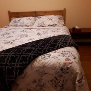 a bed with a black and white comforter and flowers at in beacon hill in Ottawa