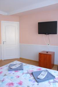1 dormitorio con 1 cama y TV en la pared en Uneed Rooms Harbour, en Kiev