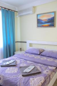 Un dormitorio con una cama morada con toallas. en Uneed Rooms Harbour, en Kiev