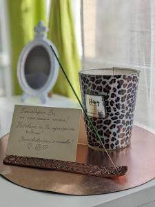 a note sitting on a table next to a vase at Zara Green Apartment 4 Guests Pet Friendly in Stara Zagora
