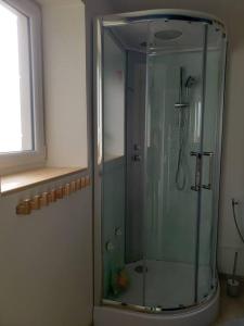 a glass shower in a bathroom with a window at Maison chaleureuse entre mer et campagne in Colombiers-sur-Seulles