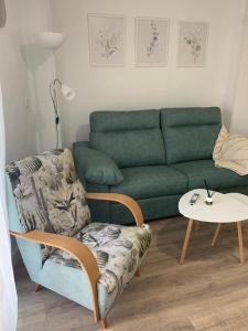 a living room with a green couch and a table at Apartamento Peñas Blancas, junto a ruta de los Cahorros, Monachil. in Monachil