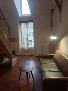 salon z kanapą, stołem i oknem w obiekcie Studio au centre de Guémené-sur-Scorff w mieście Guéméné-sur-Scorff