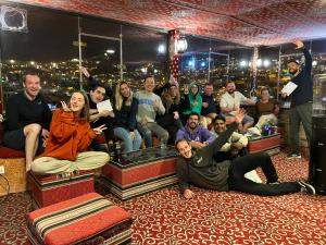 een groep mensen die poseren voor een foto in een kamer bij Rafiki Hostel in Wadi Musa