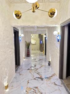 una hall con pavimento in marmo e lampadario pendente. di Ethnica Suites a Istanbul