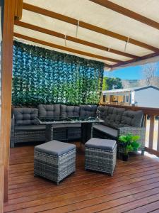 a patio with a couch and a table on a deck at Mobil-home COSY clim&tv-3 Chambres in Vic-la-Gardiole