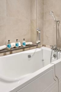 bagno con vasca e doccia di The Lodge - Studio Apartment's a Castel