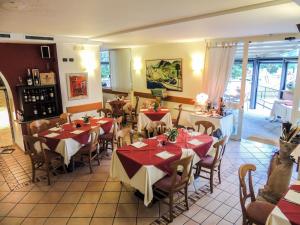 a restaurant with tables with red and white tablecloths at Albergo Lario in Gera Lario